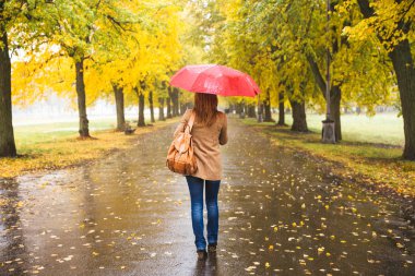 Kırmızı şemsiye, güzel sonbahar park yağmurda yürüme ile mutlu kadın.