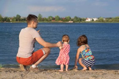 Mutlu baba ile iki kardeş yaz aylarında göl kumsalda oynarken