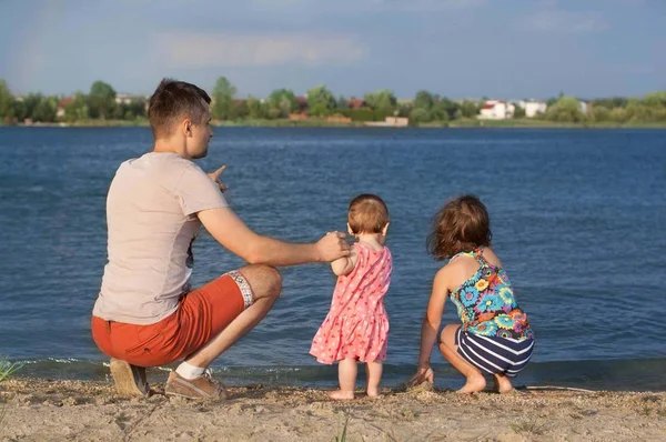 Mutlu baba ile iki kardeş yaz aylarında göl kumsalda oynarken