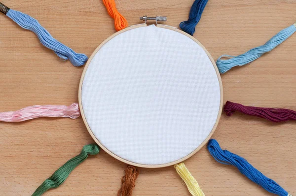 Round wooden hoop with a white cloth.
