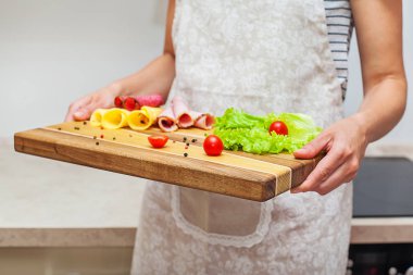 Kadın biber, sosis, salata, domates, peynir ve baharat, closeup ile bir tepsi tutar