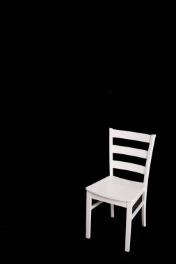 Siyah arka plan üzerine modern beyaz sandalye.