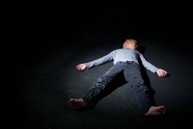 Siyah Arkaplanda Yerde Uyuyan Asyalı Çocuk. Konsept: depresyonda. Hayal kırıklığına uğradım. Duygu. Boşluğu Kopyala.