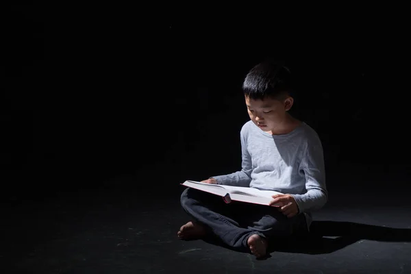 Young Cute Asian Boy Reading Book Sitting Black Background Unhappy — Stock Photo, Image