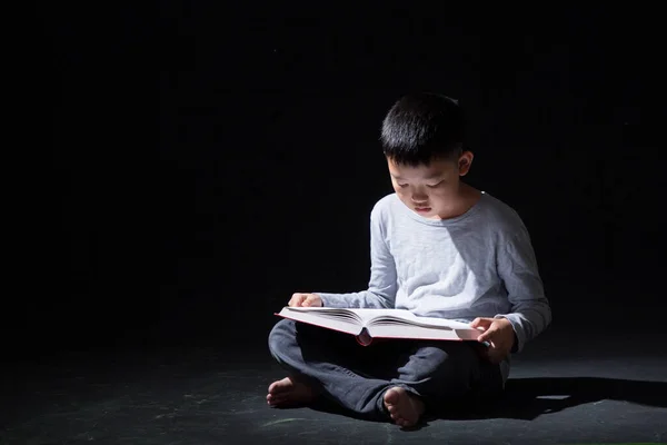 Jeune Garçon Asiatique Mignon Lisant Livre Assis Sur Fond Noir — Photo