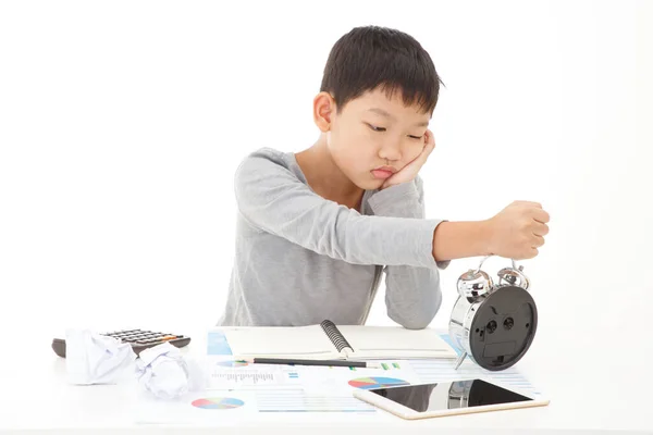 Yorgun ve bitkin Asyalı ilkokul öğrencisi. Ders çalışırken uyuyakalmak. BEYAZ GÖREVLERİNE İZLENDİ.