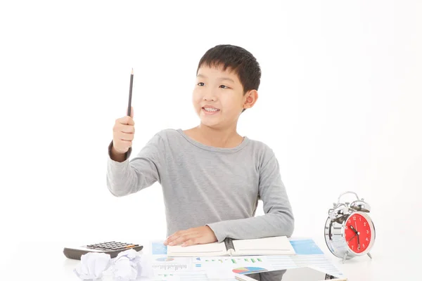 アジア系の少年は 白い背景に笑顔でノートに鉛筆書きを使用します 教育計画の考え方 — ストック写真