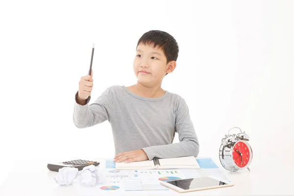 Маленький Азиатский Мальчик Пишет Карандашом Блокноте Улыбающимся Лицом Белом Фоне — стоковое фото