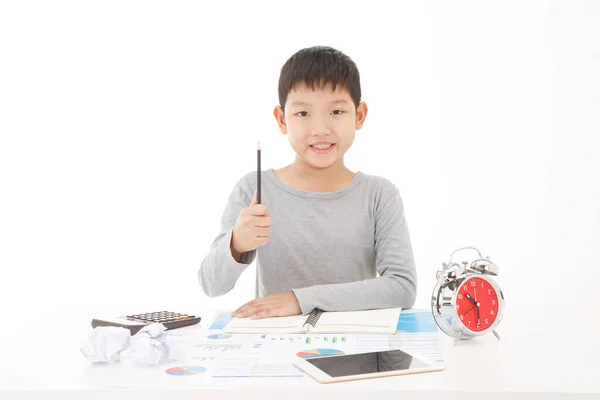 Маленький Азиатский Мальчик Пишет Карандашом Блокноте Улыбающимся Лицом Белом Фоне — стоковое фото