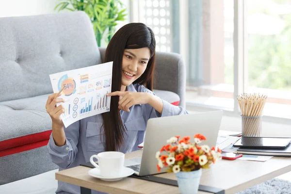 Young Cute Asian Woman feels happy while  video call Meeting on Work For Home Period. COVID-19 Lock Down. Focus on Chart. New Normal Concept.