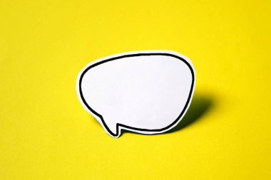 Beyaz kağıttaki boş işaret baloncuğu. Sarı kağıtta izole edilmiş..