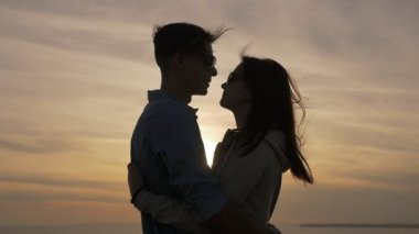 Gençlerin birbirlerini erotik günbatımı profil Karadeniz kıyısında büyülü onu tatlım yaz aylarında parlayan güneş yolu ile harika batımında kucaklayan genç bir kadın, Karadeniz kıyısında sarılmak