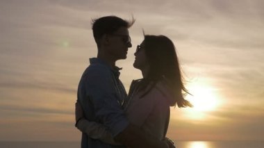 Gençler birbirlerine tutkuyla çekici genç bir kadın yaz aylarında pırıl pırıl güneş yolu ile pastoral batımında romantik onu tatlım Karadeniz kıyısında kucaklayan günbatımı profil, Karadeniz kıyısında sarılmak