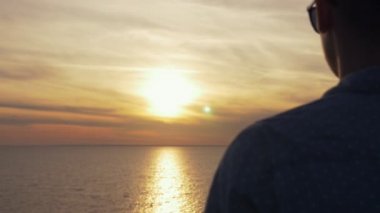 Tutkulu babası standları ve sanat konusunda hava atan günbatımı geri Karadeniz sahilinde dolly atış romantik bir gencin ayakta ve Karadeniz kıyısında çarpıcı bir güneş yol yaz aylarında gün batımında bakan güneş gözlüğü dışarı sever.
