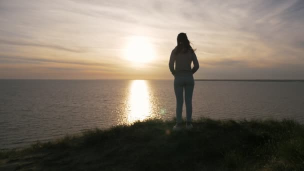 Inschrijving Meisje Een Wit Pak Staat Heuvelachtige Kust Bij Zonsondergang — Stockvideo