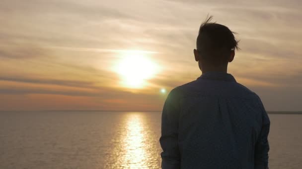 梦中的人站在黑海海岸上 享受着闪闪发光的日落 在太阳镜下 一个情绪化的年轻人站在那里 凝视着夏日灿烂的夕阳在黑海岸边风景如画的太阳路 — 图库视频影像