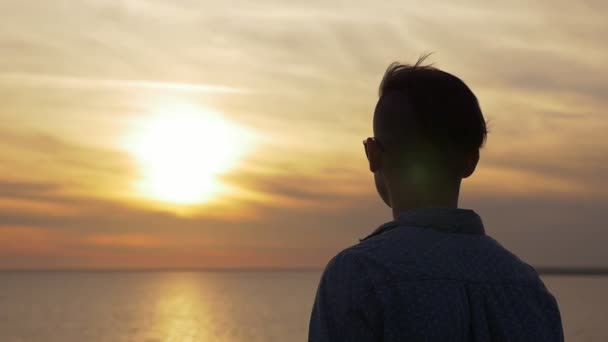 Νεαρός Άνδρας Στέκεται Και Εξετάζει Υπέροχο Ηλιοβασίλεμα Στις Ακτές Της — Αρχείο Βίντεο