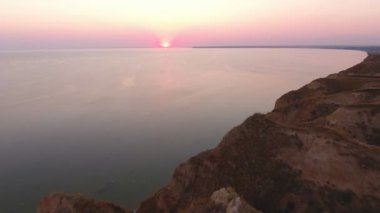 Karadeniz taç güneş hava atış yaz aylarında gün batımında kuşbakışı göz atış taçlı bir güneş ile görkemli günbatımı tepelik Karadeniz kıyısında pembe ve mor su üzerine yaz aylarında desteklemek