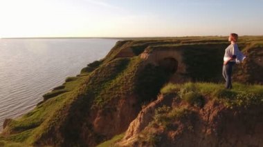 Hevesli bir kadının ellerini beline üzerinde ise Karadeniz, dikenli bir tepe üzerinde duran ve yaz aylarında parlayan güneş yol zevk tutmak yaz hava tavada güzel günbatımında Karadeniz kıyısında duran mutlu sarışın kadın