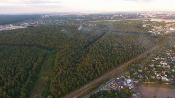 Vue aérienne de la banlieue de Kiev avec une autoroute traversant une forêt dense Une vue pittoresque sur la périphérie de Kiev avec un haut bois de pin, une autoroute droite et de nombreuses petites maisons en été 