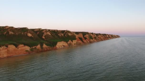 空中ショット薄いと黒海の海岸の Susnset の素晴らしい概観図ビューで緑の中空ストレート黒海の海岸の豪華な夏のバラ色と青い空とサンセットで頑丈な緑の丘で — ストック動画