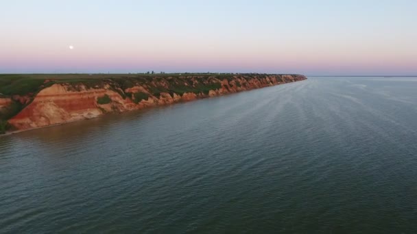 Vue aérienne d'une côte montagneuse avec des ravins de la mer Noire au coucher du soleil Vue aérienne pittoresque du rivage de la mer Noire avec de minces creux dans des collines escarpées au coucher du soleil avec un ciel rose et bleu en été 