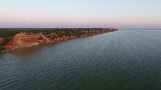 ピンクとブルーの空と夏の夕暮れ時の急な丘に細いくぼみ海岸黒海の Susnset の絵のような鳥の目のビューで黒海の峡谷をこの時海岸の空中ショット — ストック動画