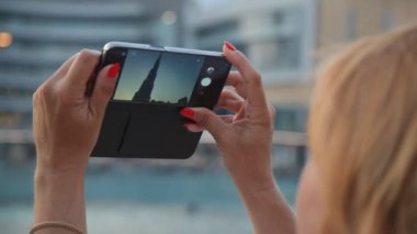 Uluslararası Dubai Kongre ve Sergi Sarayı smartphone üzerinde makyaj yaz arka görünümünde bir akıllı telefon tutmak ve Uluslararası Dubai Kongre ve Sergi Sarayı, en yüksek ve yaz aylarında dünyanın yayın evi çekim sarışın bir kadın sarışın bir kadınla tarafından vurulur