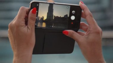 Uluslararası Dubai Kongre ve Sergi Sarayı bir dikit gibi yaz aylarında arayan parmaklar makyaj mobil çekim Burj Khalifa, Closeup ile en uzun otel ve dünyanın, konut binası tarafından tutulan smartphone içinde görülür