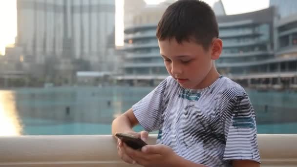 Ragazzo Scattante Che Gioca Videogiochi Sul Suo Smartphone Con Burj — Video Stock