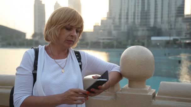 Elegante Blonde Frau Die Mit Telefon Und Burj Khalifa Einem — Stockvideo