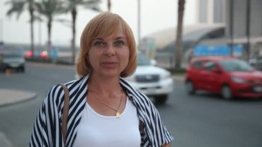 Ayakta ve karayolu ile Dubai palms ince bir kadın ayakta ve neşeyle Dubai avuç içi ile modern bir otoyol yaz aylarında güneşli bir gülümseyen iyimser bir bakış gülümseyen mutlu kadın turist
