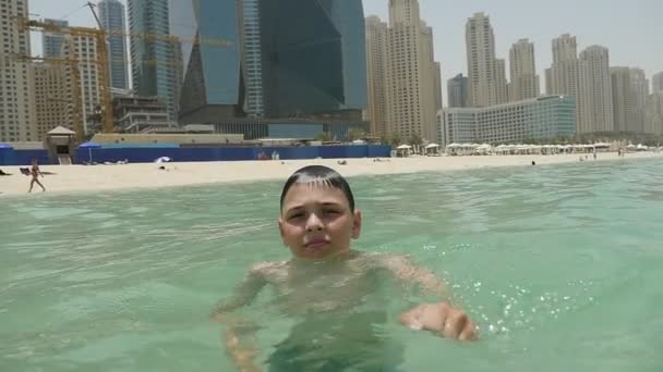 Маленький Хлопчик Плаває Море Громадські Пляжі Покриті Пісок Дубай Влітку — стокове відео