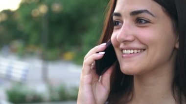 Mutlu kız gülümseyerek ve telefonda onun Bay doğru ile yaz neşeli ve şık genç bir kadın portresi Smartphone'da yaz aylarında nehir üzerinde erkek arkadaşı ile konuşurken parlak gözlü sohbet 