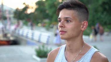 Romantik adam ayakta ve onun girlon için yaz aylarında gün batımında nehir bir limanda bekleyen bir singlet kısa bir saç kesimi ile yaz profil thoughtfu genç bir adamın günbatımında bir nehir iskele Ukrayna bekliyor
