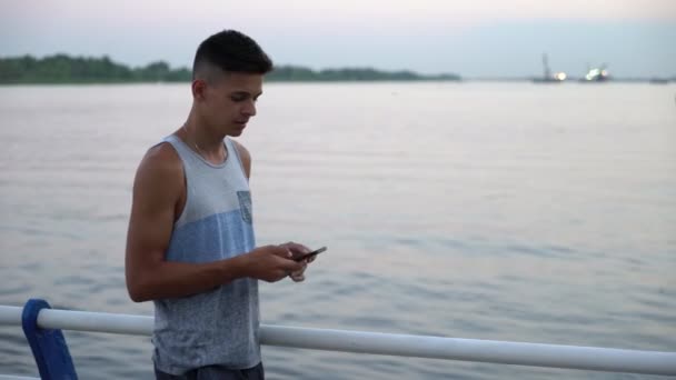 Sportive Man Stands Browses Net River Quay Sunset Summer Perfil — Vídeo de Stock