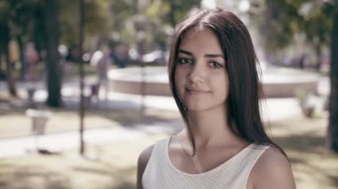 Romantik kız ayakta ve şefkatle yaz uzun saçlı ve beyaz bir elbise içinde duran ve yaz onun erkek arkadaşı bir parkta düşünüyorum dayanılmaz gülümseme ile ince bir kız portresi yeşil bir parkta gülümseyen