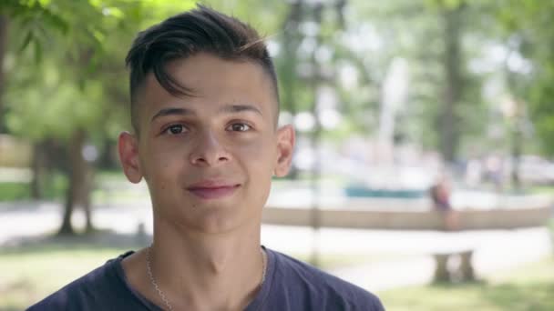 Jeune Homme Tient Debout Sourit Joyeusement Dans Une Allée Verte — Video