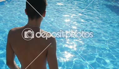 Akıllı çocuk kafa önce slo-mo yaz yavaş geniş yüzme havuzu gök mavisi suya atlama kısa filmlerde sportif bir genç iyimser bir bakış Camgöbeği mavi su ile bir yüzme havuzunda atlar