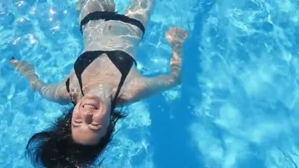 Веселый Взгляд Счастливую Женщину Черном Бикини Улыбающуюся Лежащую Голубой Воде — стоковое видео