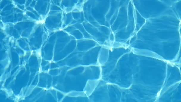 浅蓝色游泳池闪烁着它变幻的水晶般的海水在一个通风的水池里摇曳的天空蓝色的水的鼓舞人心的看法 明亮的波浪线塑造快活和乐观的背景 — 图库视频影像