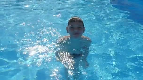 Улыбающийся Мальчик Стоит Голубой Воде Сверкающего Бассейна Замедленной Съемке Забавный — стоковое видео
