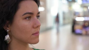 Romantik genç kadın arkadaşı insanlar derin eys ve etrafa ve bir cam gibi eğlence merkezinde Mr.Right için bekleyen dalgalı saç ile büyüleyici bir esmer kadın profili ile geniş bir salonda bekliyor