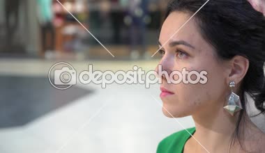 Oturan, yukarıya bakıp bir salonda oturan, yukarıya bakıp mutlu insanlarla bir etertainment ortasında gülümseyen moda küpe ile insanlar güzel bir genç kadının profili ile gülümseyen glamour esmer kadın