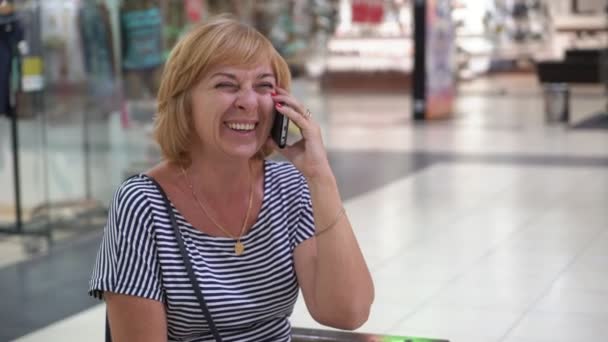 Vrolijke Blonde Vrouw Zitten Praten Haar Telefoon Een Ruime Hal — Stockvideo