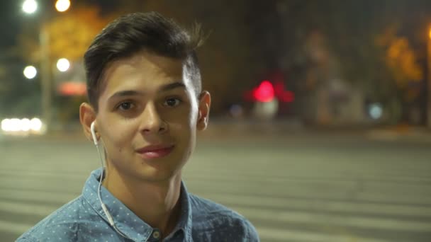 Веселий Хлопець Слухає Музику Стоїть Вулиці Трафіком Вночі Портрет Усміхненого — стокове відео