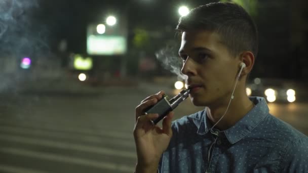 Homem Relaxado Está Ouvindo Música Fumando Cigarro Eletrônico Livre Noite — Vídeo de Stock