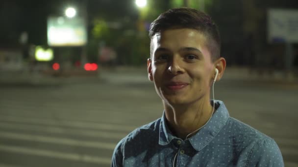 Joven Alegre Sonríe Escuchando Música Una Calle Con Auriculares Los — Vídeo de stock