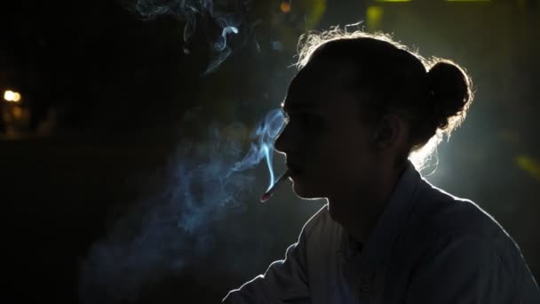 Junger Mann Sitzt Und Raucht Einer Dunklen Straße Mit Fahrenden — Stockvideo
