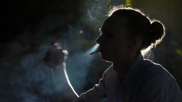 Junger Bohemien Sitzt Denkt Und Raucht Eine Zigarette Einem Dunklen — Stockvideo